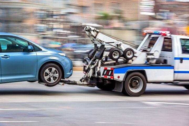 Lexington Towing Co flatbed tow truck hauling a blue car in Lexington KY