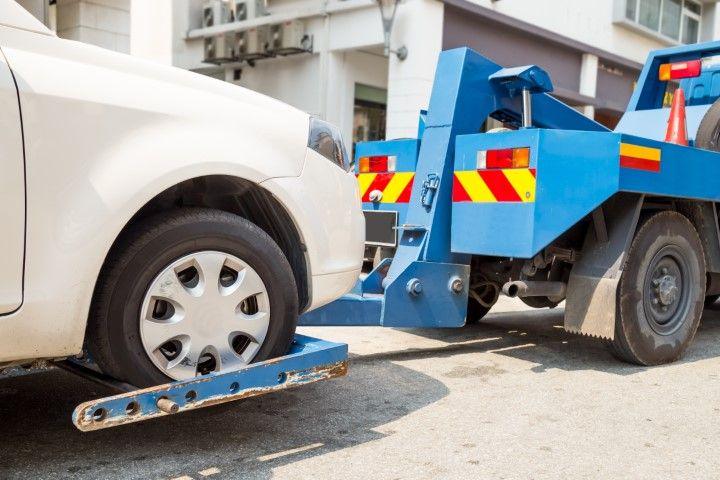 Blue Lexington Towing Co tow truck towing a grey car